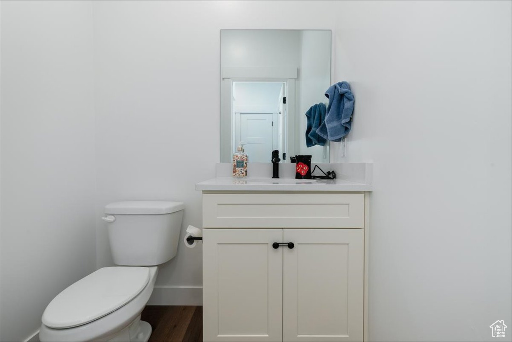 Half bath featuring vanity and wood finished floors