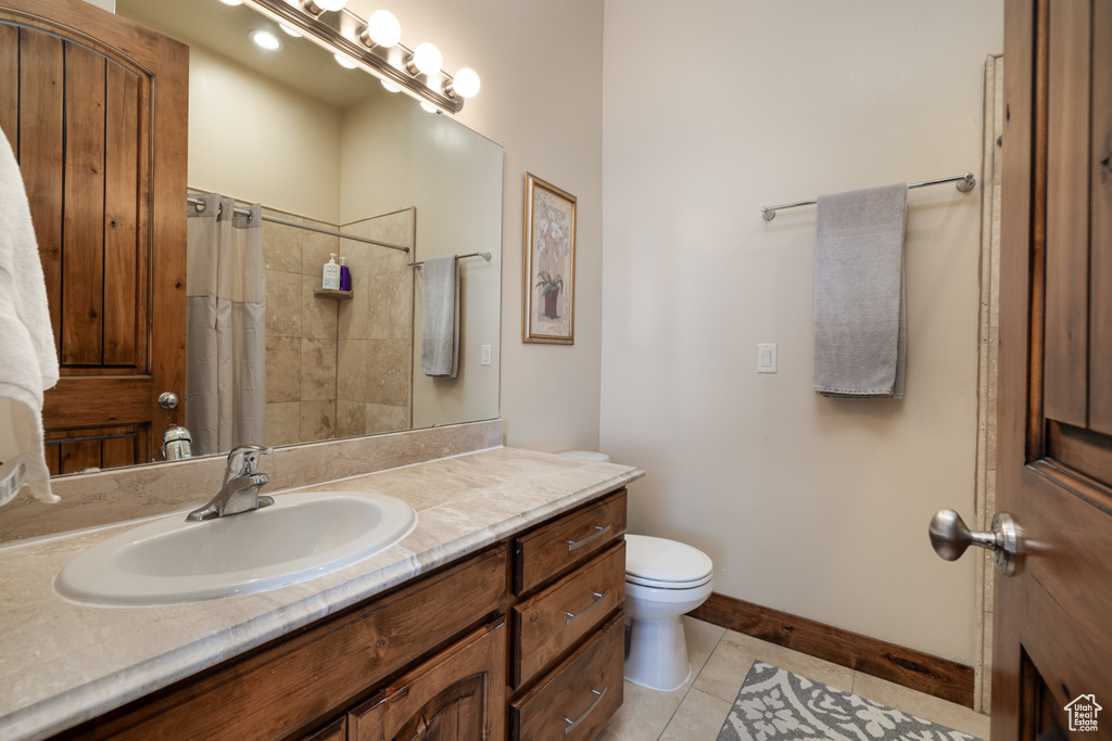 Bathroom with tile patterned flooring, vanity, and curtained shower