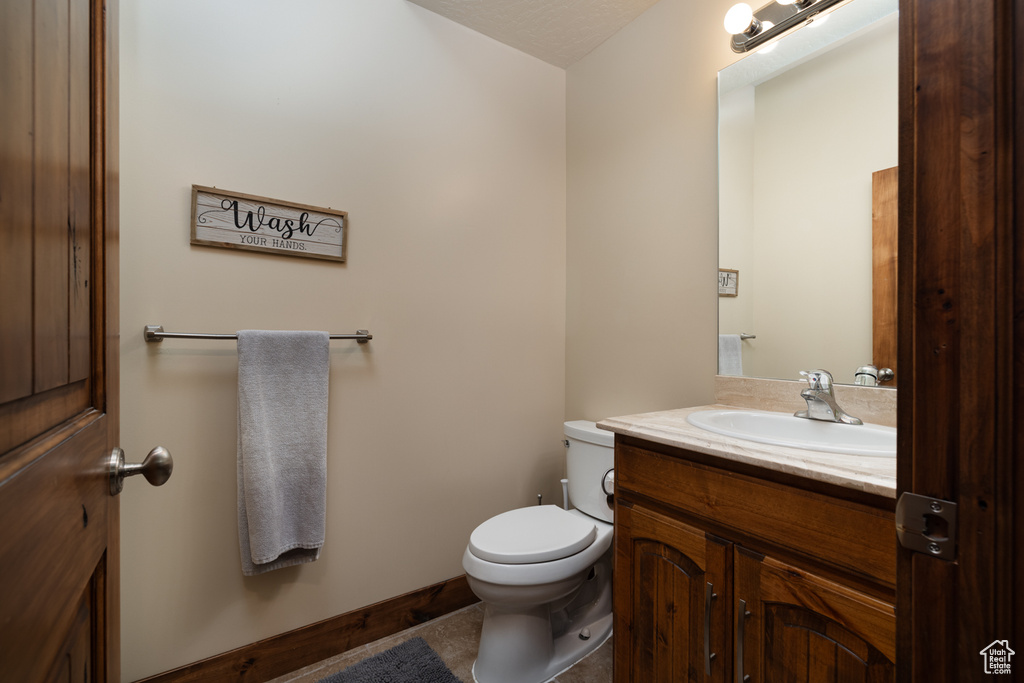 Half bathroom featuring vanity and toilet
