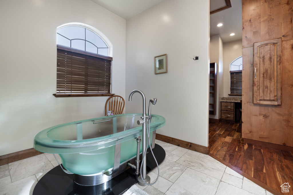 Bathroom featuring a soaking tub and healthy amount of natural light