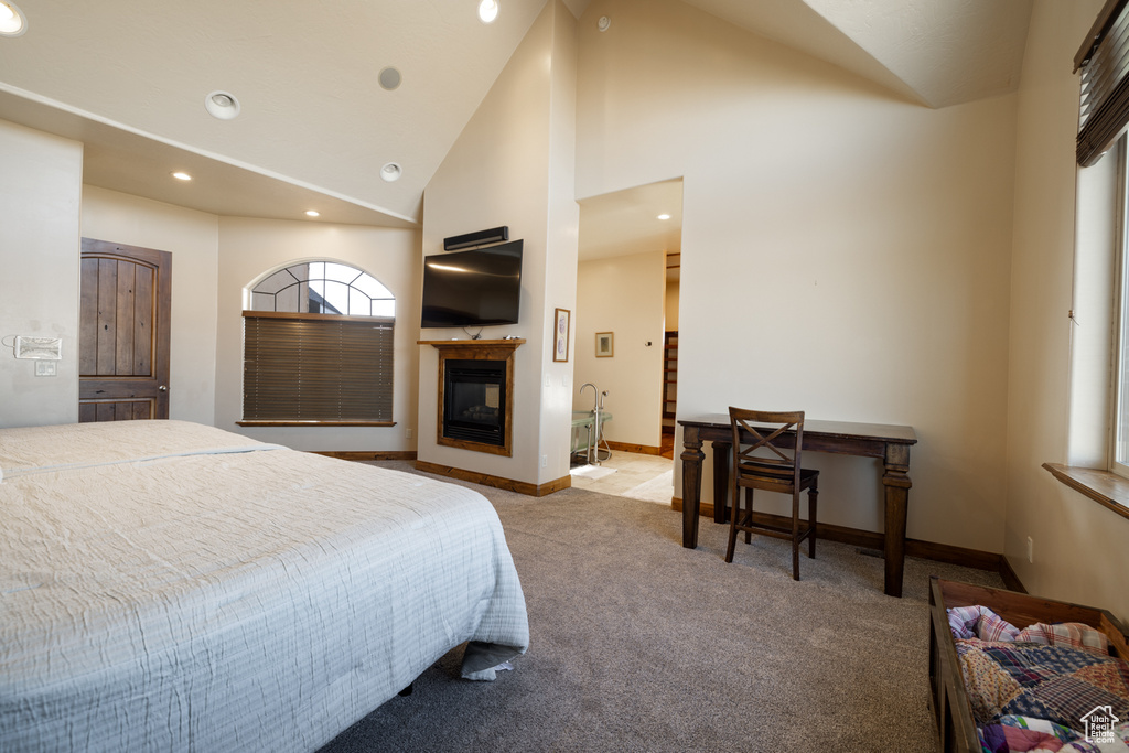 Bedroom featuring light colored carpet, recessed lighting, a multi sided fireplace, and high vaulted ceiling