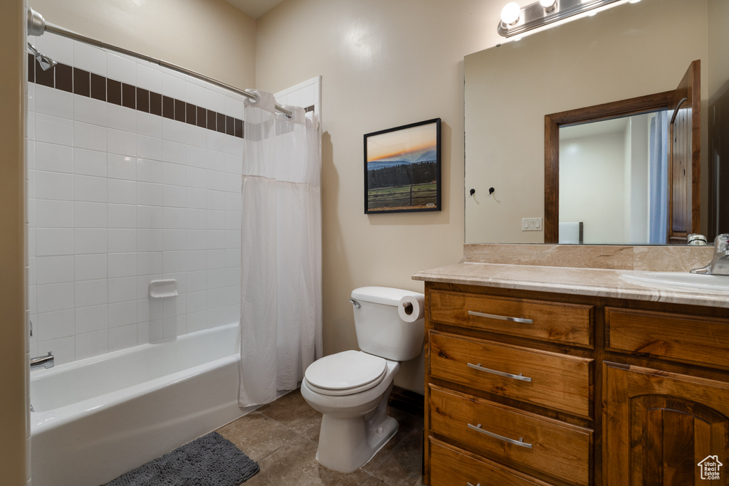 Bathroom with vanity, shower / bath combo, and tile patterned flooring