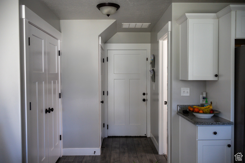 Hall featuring dark wood finished floors and baseboards