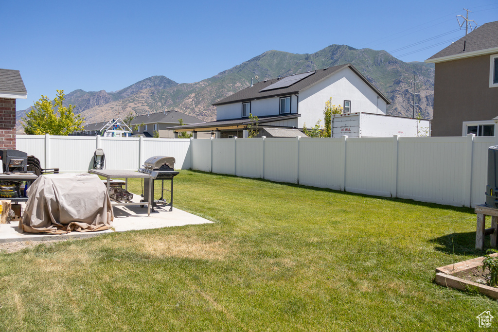 Fenced backyard featuring a mountain view and a patio area