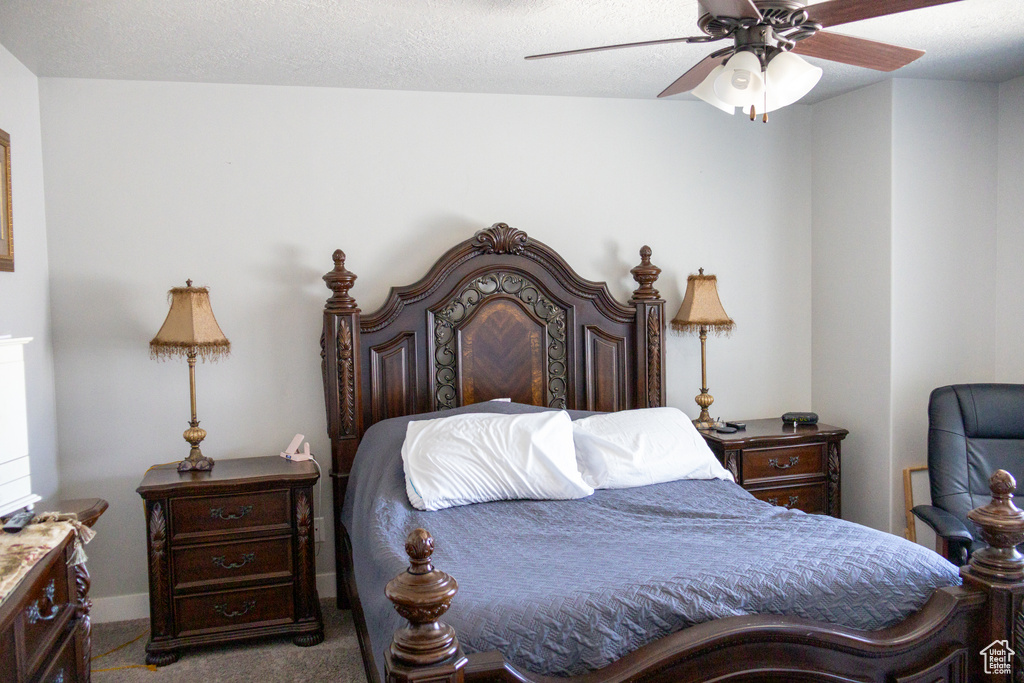 Carpeted bedroom with a ceiling fan and baseboards