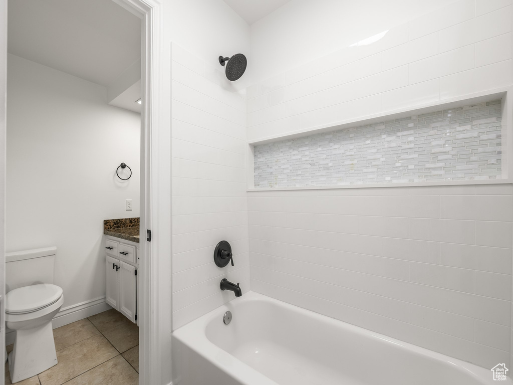 Bathroom featuring tile patterned flooring, tub / shower combination, and vanity