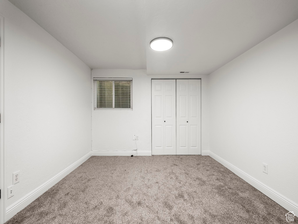 Unfurnished bedroom with carpet flooring and a closet