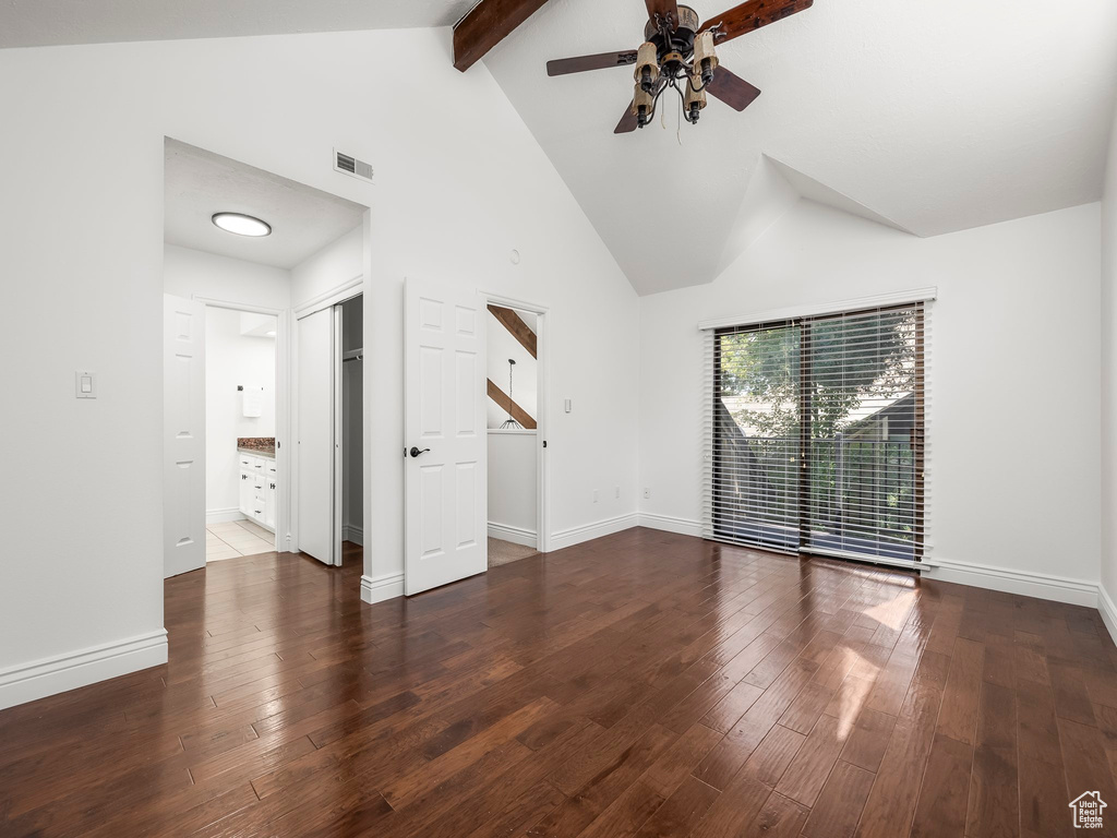 Unfurnished living room with a ceiling fan, beam ceiling, wood-type flooring, and high vaulted ceiling