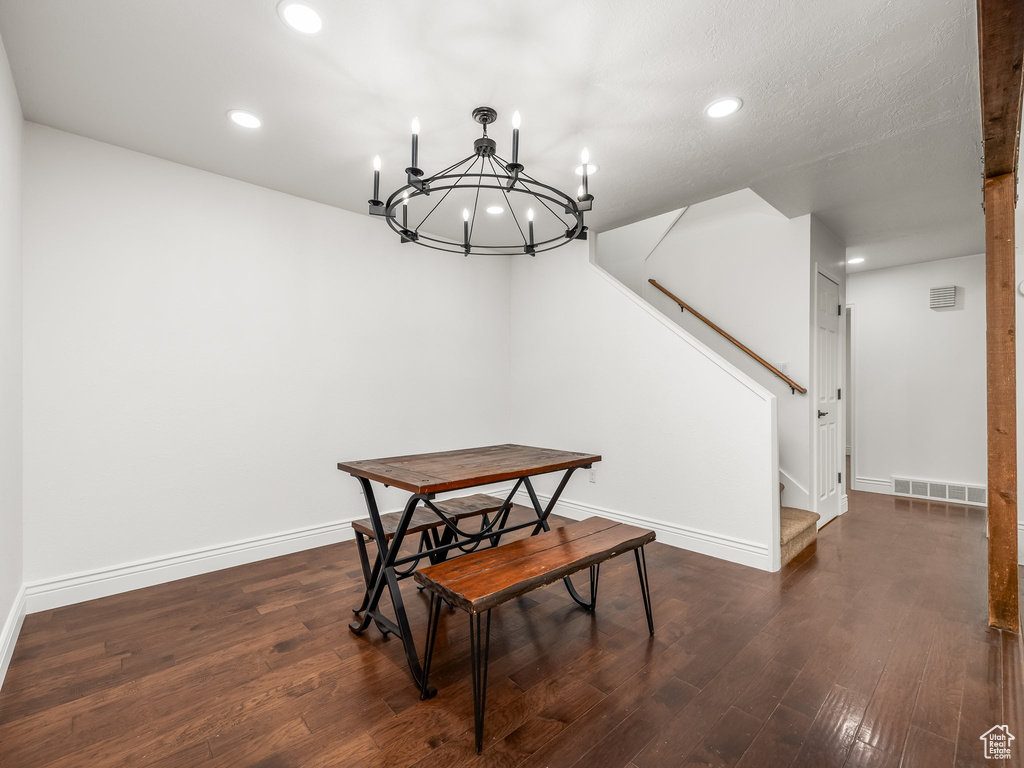 Dining area featuring dark wood-style floors, recessed lighting, a chandelier, and stairs