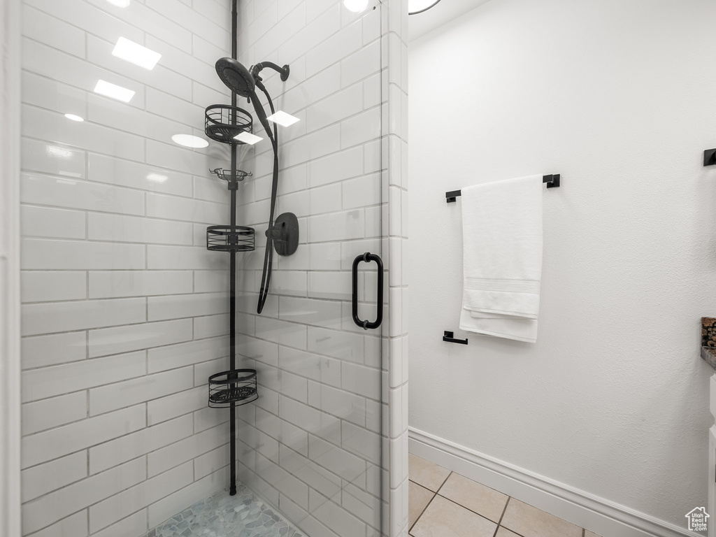 Bathroom with a shower stall and tile patterned floors