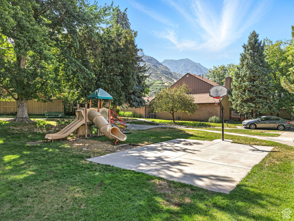 Community playground featuring a lawn and a mountain view