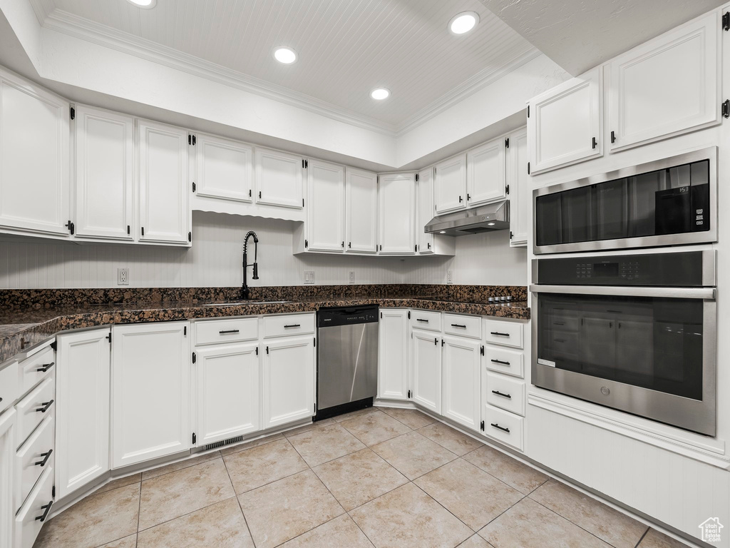 Kitchen with stainless steel appliances, crown molding, recessed lighting, under cabinet range hood, and white cabinets