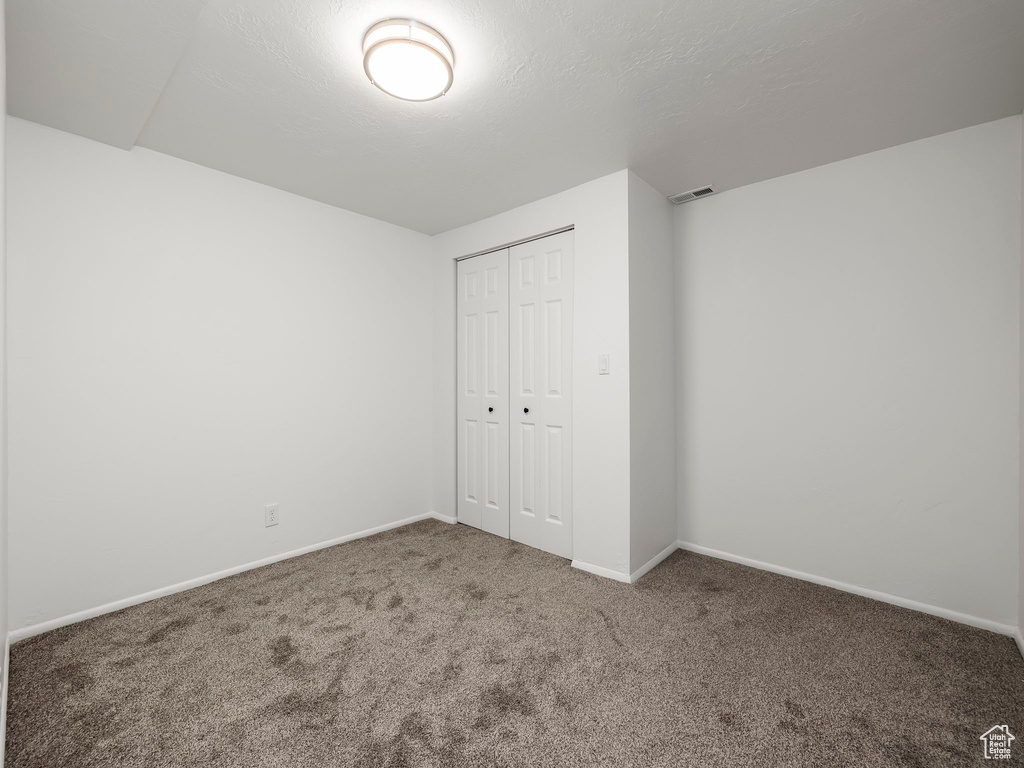 Unfurnished bedroom featuring carpet floors and a closet