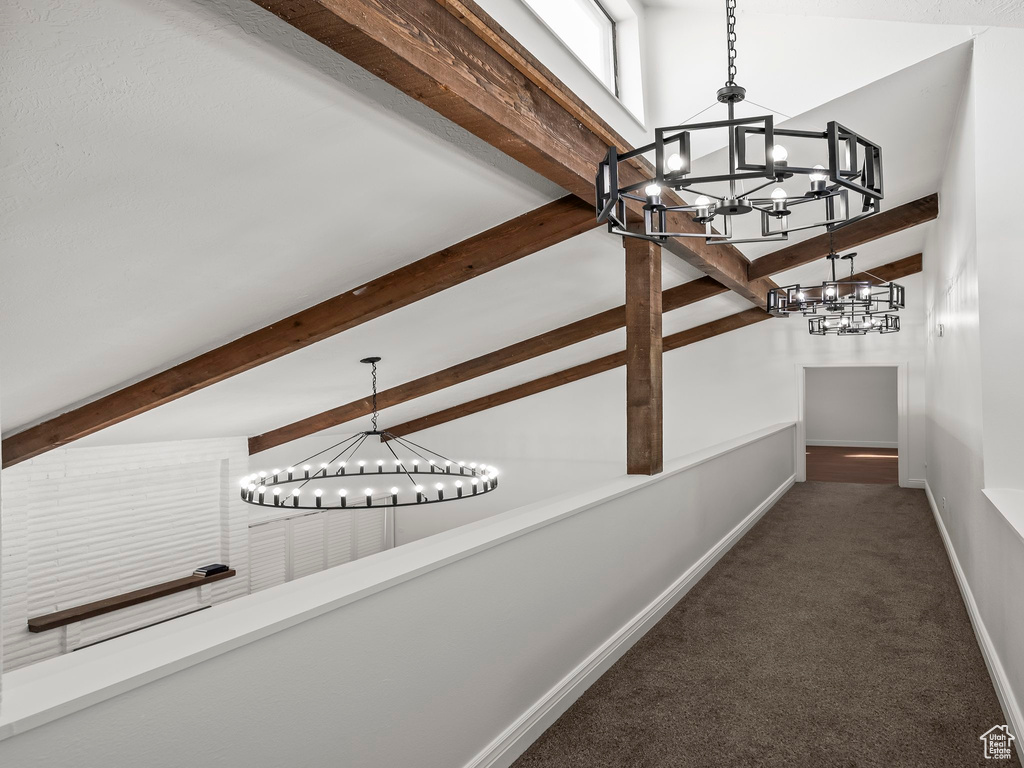 Hallway featuring a chandelier, beam ceiling, high vaulted ceiling, and carpet floors