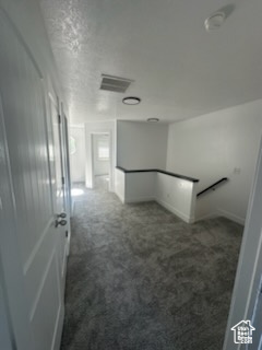 Hallway featuring an upstairs landing and carpet floors