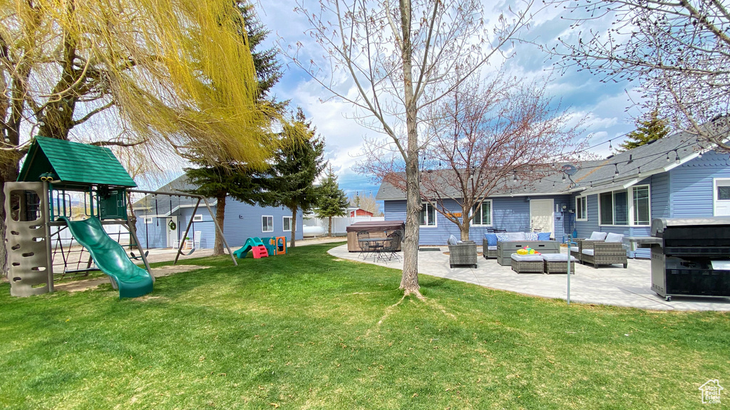 View of green lawn with an outdoor living space, a patio area, and a playground