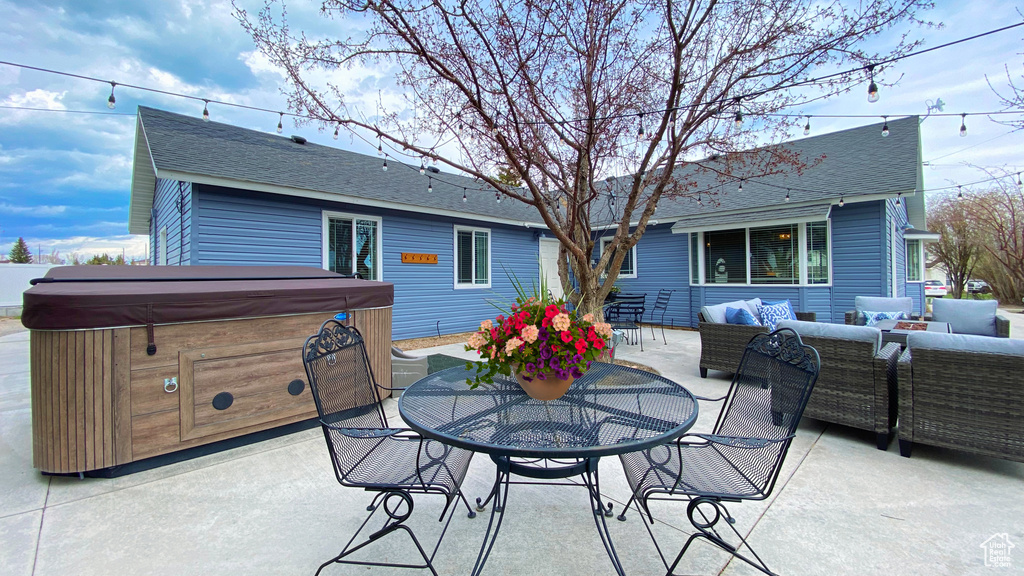 View of patio with a hot tub, an outdoor living space, and outdoor dining area