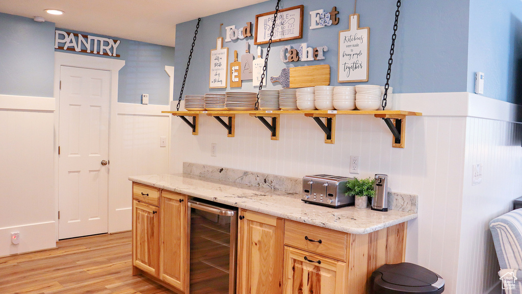 Indoor dry bar with wine cooler, light wood-style flooring, a wainscoted wall, and recessed lighting