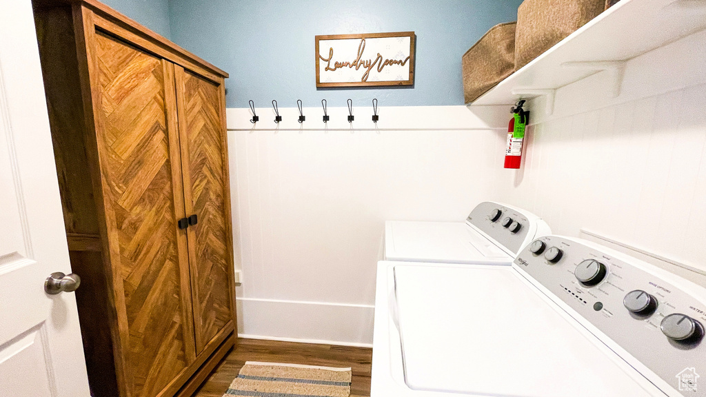Laundry area with washing machine and dryer and wood finished floors