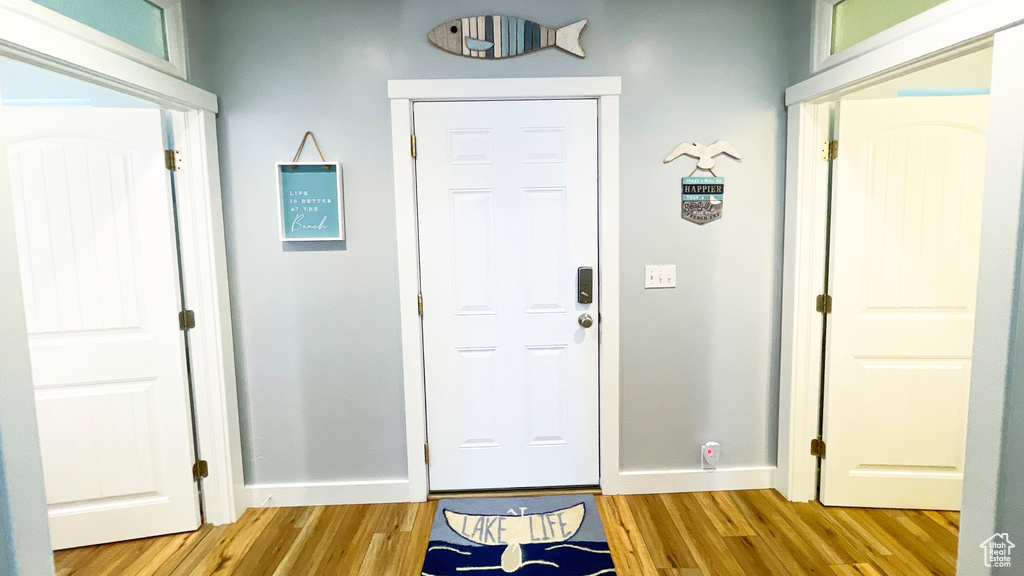 Entryway with light wood finished floors and baseboards
