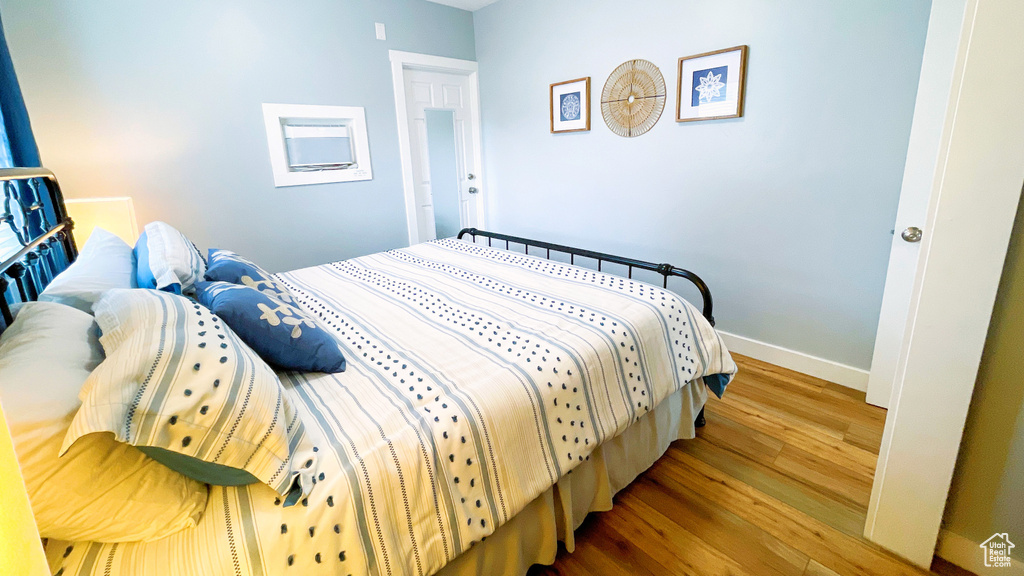 Bedroom with wood finished floors and baseboards