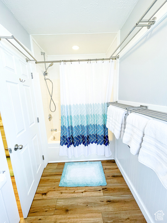 Bathroom featuring shower / bath combo with shower curtain and wood finished floors