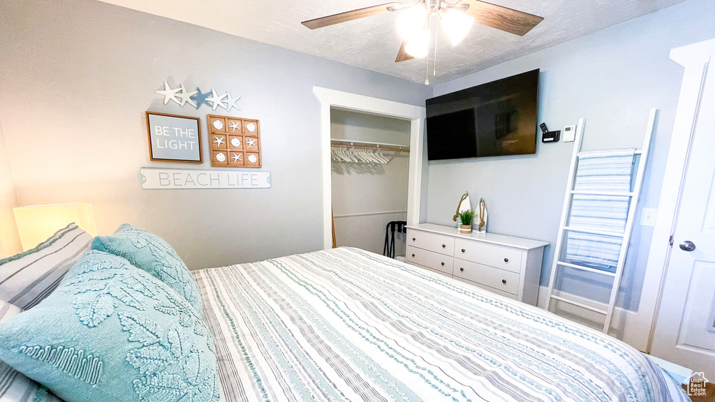 Bedroom featuring a closet, ceiling fan, and a textured ceiling