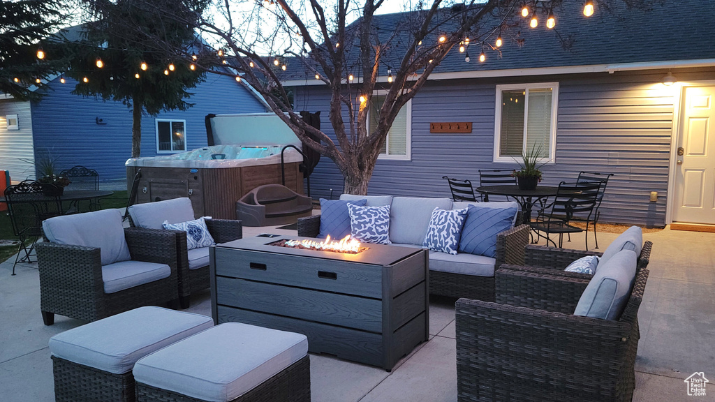 View of patio / terrace featuring a hot tub and an outdoor living space with a fire pit