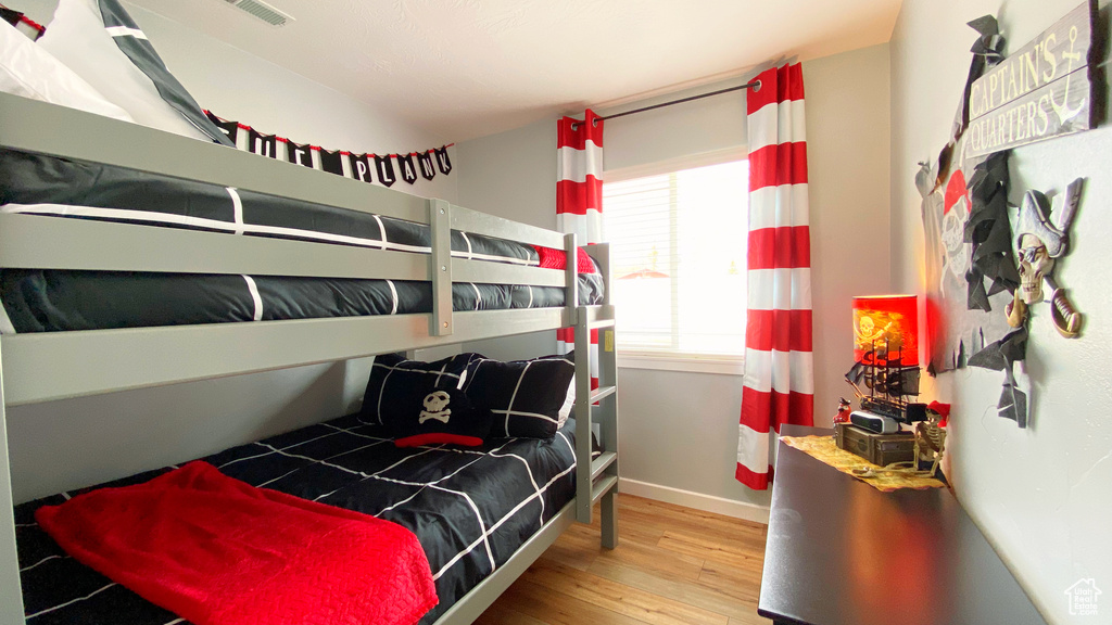 Bedroom with wood finished floors and baseboards