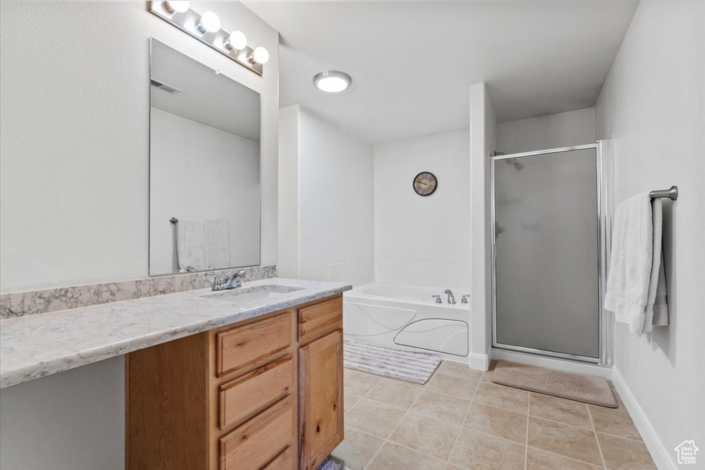 Full bath featuring vanity, a bath, a shower stall, and tile patterned floors