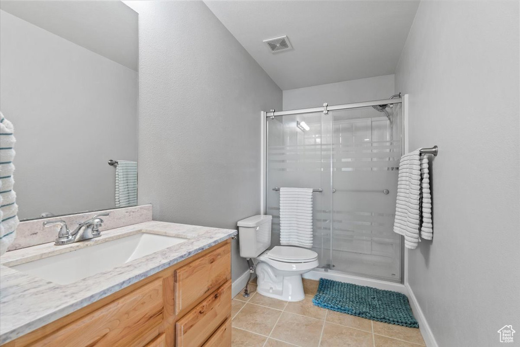 Bathroom featuring tile patterned floors, vanity, and a stall shower