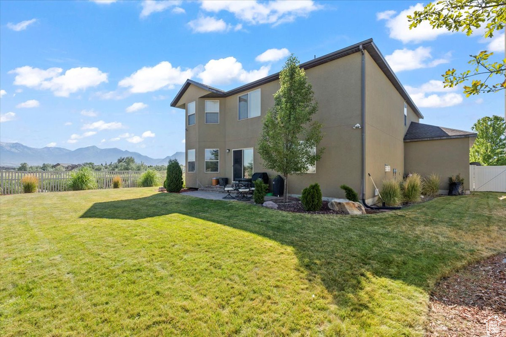 Back of property featuring a patio, a fenced backyard, stucco siding, and a mountain view