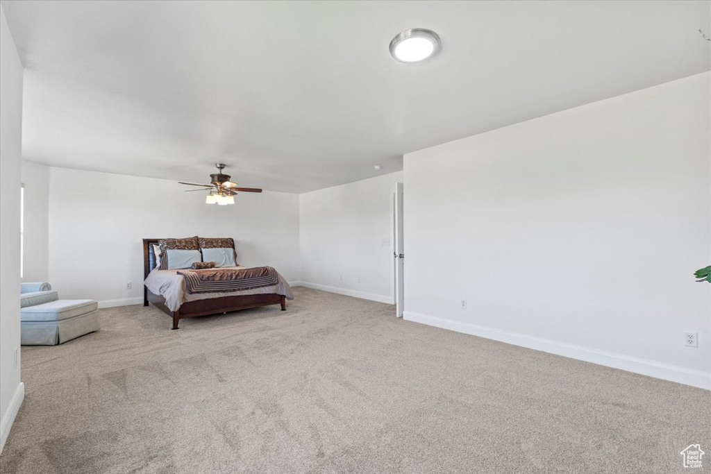 Carpeted bedroom featuring baseboards and ceiling fan