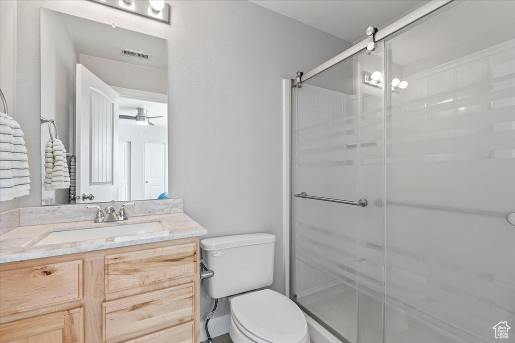 Full bathroom with vanity, a shower stall, and ceiling fan