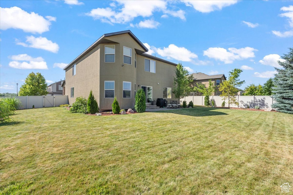 Back of property with a fenced backyard, stucco siding, and a patio area