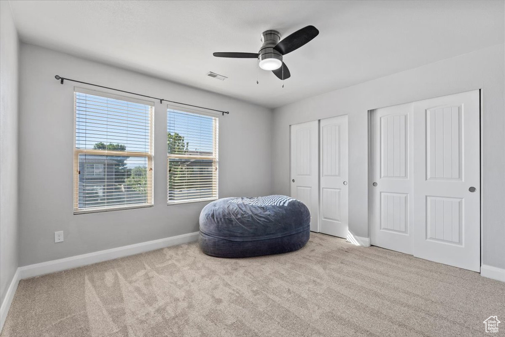 Sitting room featuring carpet flooring and a ceiling fan