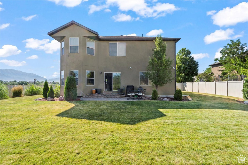 Back of property with stucco siding, a patio area, and a mountain view