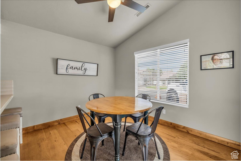 Dining area featuring lofted ceiling, ceiling fan, and light wood-style floors