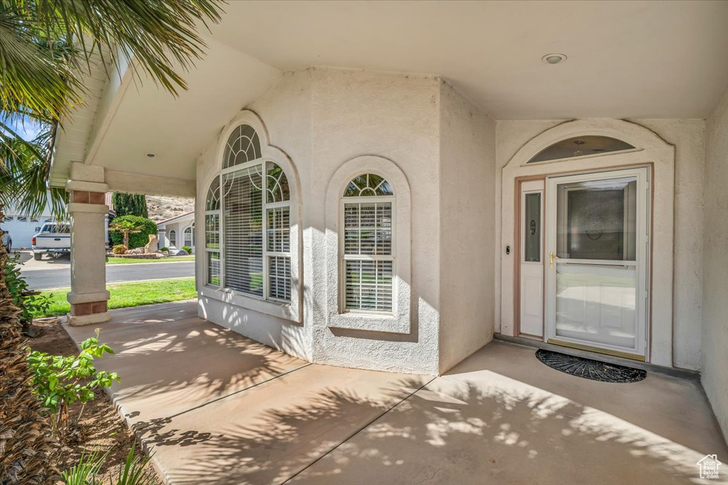View of exterior entry featuring stucco siding and covered porch
