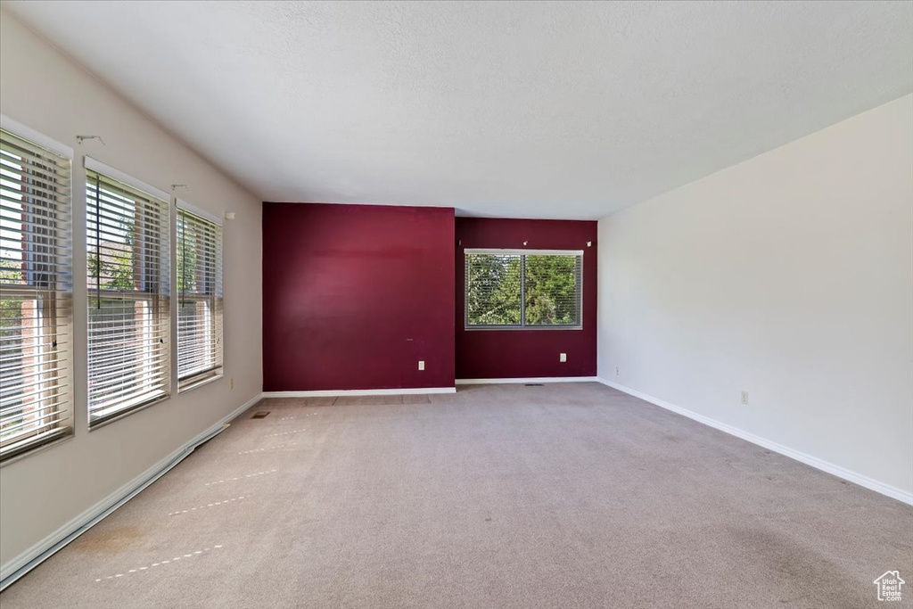 Carpeted empty room featuring healthy amount of natural light