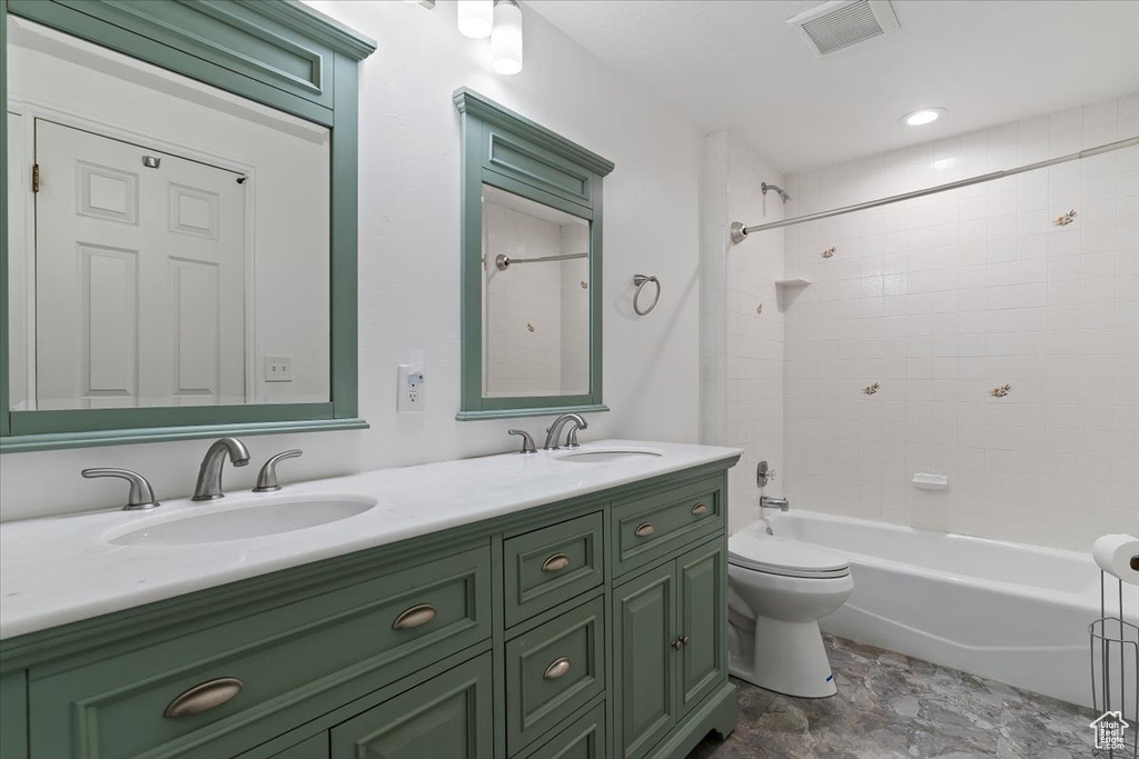 Full bathroom with double vanity and tub / shower combination