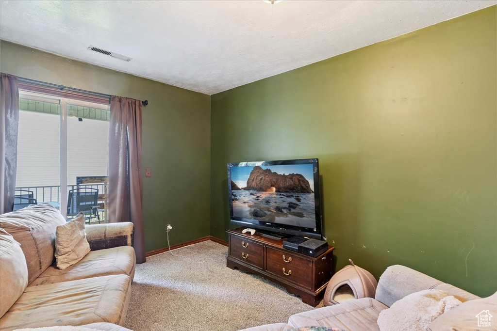 Living area featuring light carpet and baseboards