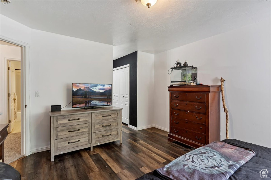Bedroom featuring dark wood finished floors and a closet