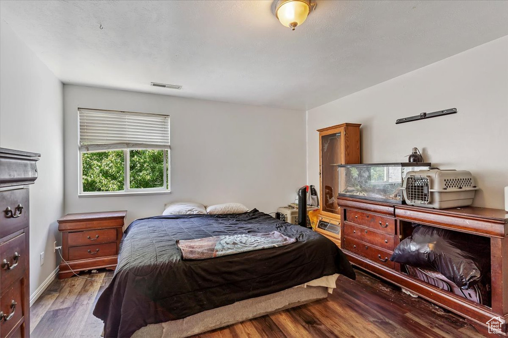 Bedroom with wood finished floors and baseboards