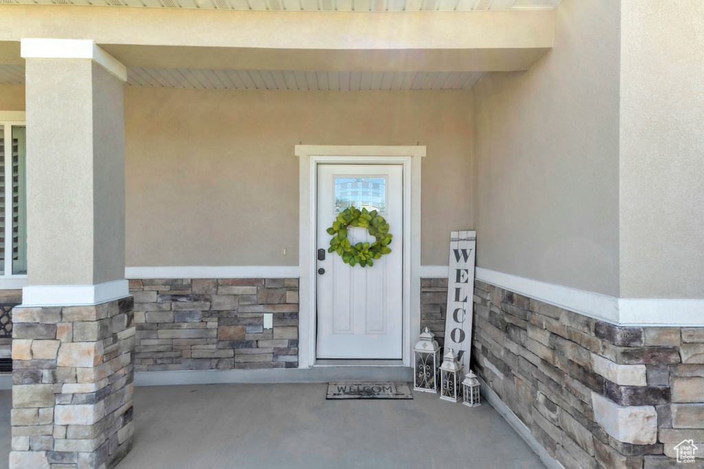 View of exterior entry with stone siding and stucco siding