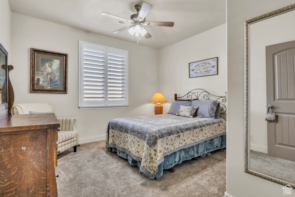 Carpeted bedroom featuring baseboards and a ceiling fan