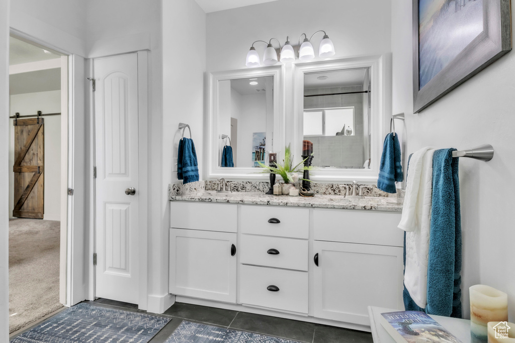 Bathroom with double vanity and tile patterned flooring