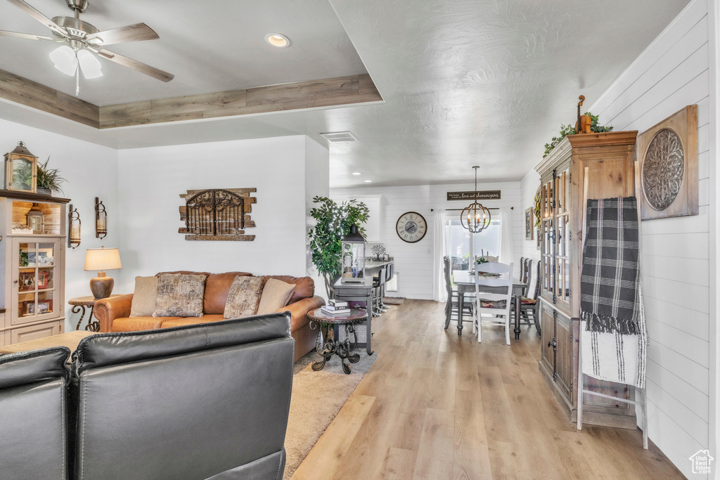 Living room with light wood-style flooring, a chandelier, ceiling fan, and recessed lighting