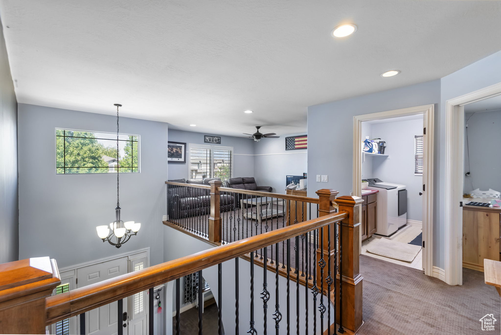 Corridor with an upstairs landing, washing machine and dryer, a chandelier, carpet, and recessed lighting