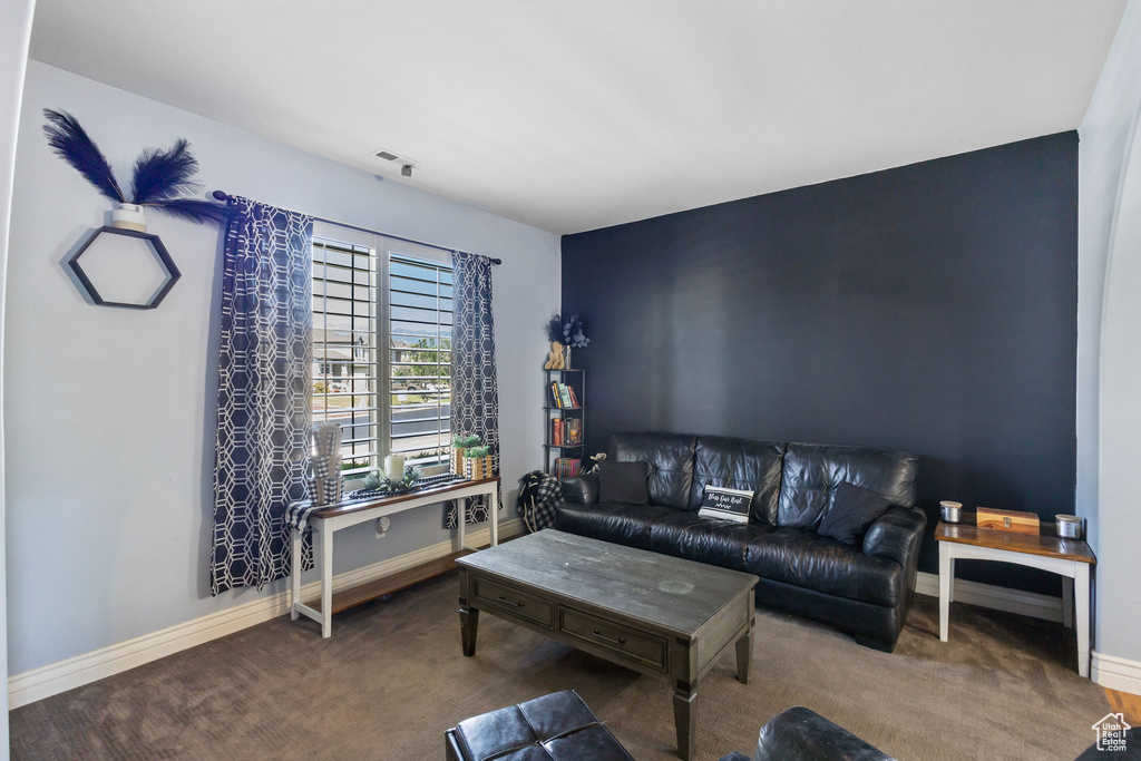 Carpeted living area featuring baseboards